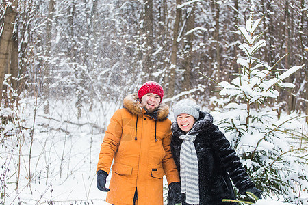 爱情 季节 友谊和人的概念 — 快乐的年轻男女在冬季森林里玩雪 夫妻 微笑图片