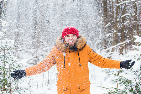 年轻人在冬天的森林里扔雪 在户外玩得开心的人 冬季活动 情绪 舒适图片