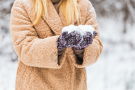 近身的女子手握着雪 冬天的概念 滚雪球 十二月 乐趣背景图片
