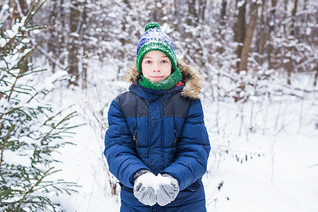 可爱的小男孩玩雪 玩得开心 微笑 冬季公园的少年 积极的生活方式 冬季活动 户外冬季运动会 雪球 围巾 雪橇图片