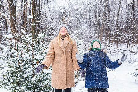 父母 欢乐与季节概念——快乐的母亲和儿子在冬季森林中玩得开心 玩雪游戏 衣服 雪花图片