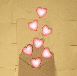 纸制工艺信封 棕色纯色背景上有粉红色的心 爱的概念和情人节 Daytop 视图复制 spac图片
