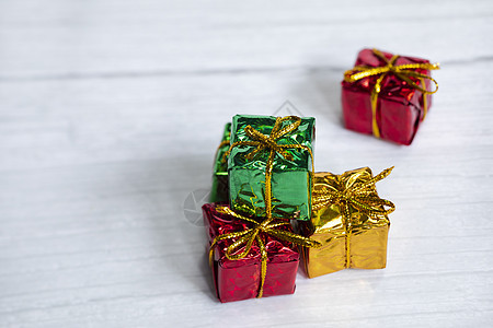 一堆彩色闪亮的礼盒 白色木质背景上有复制空间 现代复古圣诞设计 色彩缤纷的礼物 假日概念 庆典 金的图片