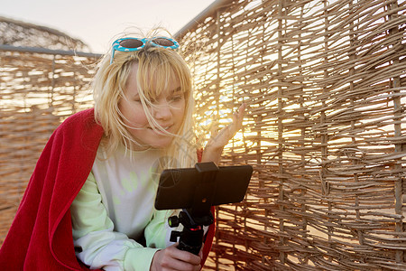 女青少年在智能手机上录制视频的室外日落肖像 旅游 快乐的图片