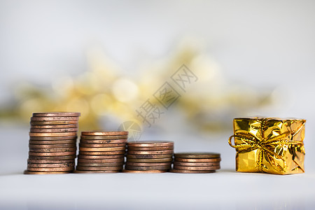 带圣诞假期的硬币爬楼梯呈现闪闪发光的背景财务 节省硬币概念堆 雪 庆典背景图片