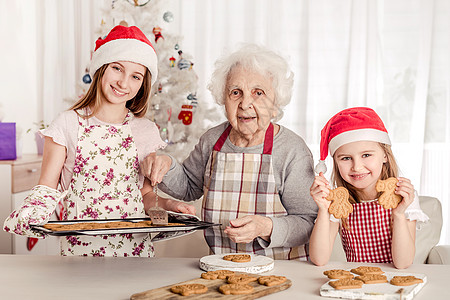 圣诞帽女孩外婆 外孙女和外孙女一起烤饼干 圣诞帽 退休 新年背景