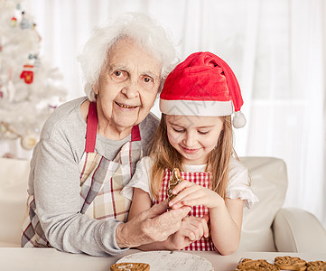 外祖母和孙女抱着面包饼干 孩子 奶奶 祖父母 厨房图片