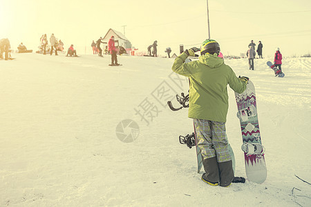穿着滑雪西装和滑雪板看山上的人图片