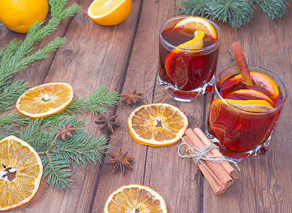 圣诞红酒在木制背景上 配有香料 树枝和干橙 花环 冬天图片