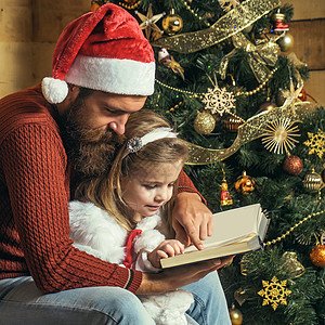 圣诞圣誕老人父亲和女儿读书 冬季家庭节在家度假图片