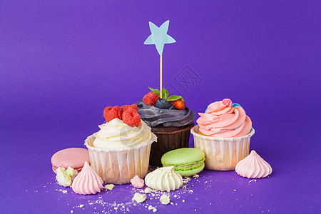 与饱和的深紫色背景对比的美丽蛋糕 磨砂 糖果图片