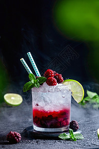 酒鸡尾酒与Rum或Vodka Soda Raspberry和 Lime和Mint在暗灰底烟雾的玻璃杯中图片