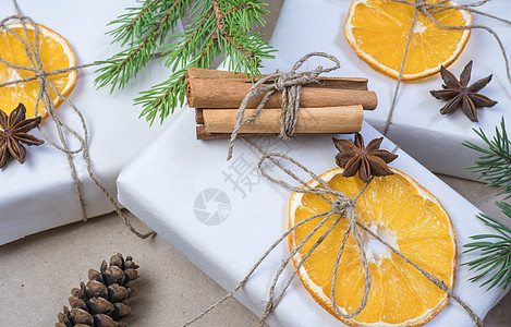 新年作文 在米色牛皮纸 礼品盒 干橙片 松果 肉桂 丁香 云杉树枝上 舒适的圣诞节概念 面目全非 复古的图片