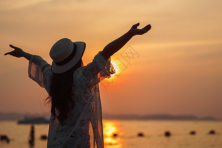 女人在海边享受日落 自由的 海洋 上调 微笑 天空图片
