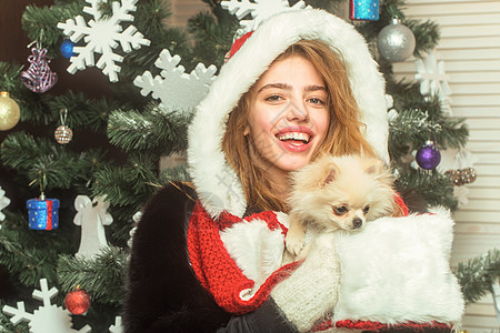 可爱的年轻女人抱着小狗 圣诞快乐的脸和宠物的女人 聚会庆典和圣诞节 狗年寒假和圣诞节图片