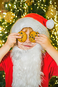 圣诞老人有趣的孩子采摘饼干 小圣诞老人拿着圣诞饼干对着眼睛图片