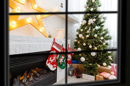 透过窗户 圣诞树在背景上 冬季假期的概念 笑声 家庭 圣诞故事图片