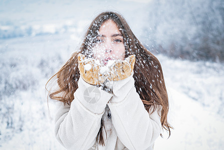 冬天快乐的女孩吹雪 冬天假期的年轻女人图片