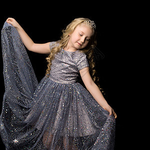 一个小女孩穿着长长优雅的公主礼服 身着黑色背景的公主 时尚 孩子图片
