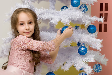 年轻女孩在白圣诞树前和蓝鲍鱼一起游荡 家图片
