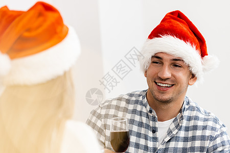 年轻夫妇在圣诞老人的帽子 喝着葡萄酒和庆祝圣诞节 派对 女性图片