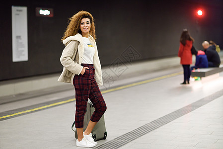 年轻的阿拉伯女人在地铁站等火车 她叫阿波拉人? 女孩图片