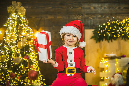 快乐可爱的孩子戴着圣诞老人的帽子带着礼物过圣诞节 圣诞节孩子男孩送礼图片