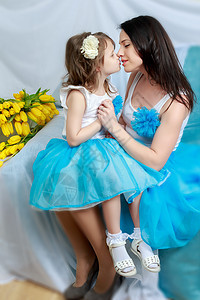 妈妈和女儿在沙发上 带着一束花 春天 爱 礼物图片