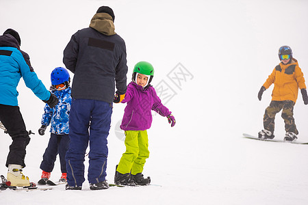 在寒风天 山上滑雪度假胜地 父亲教小女儿滑雪 女孩 单板滑雪图片