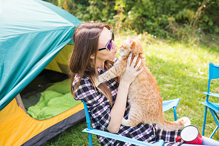 人民 旅游和自然概念   太阳镜中的妇女坐在帐篷旁边的猫 冒险 快乐的图片