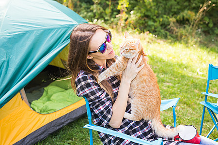 人民 旅游和自然概念   太阳镜中的妇女坐在帐篷旁边的猫 夏天 快乐的图片