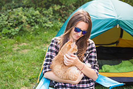 人民 旅游和自然概念   太阳眼中的女性在帐篷附近扎一只猫图片