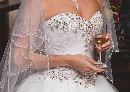 穿着白色婚纱的新娘 盛着香槟 特写图片