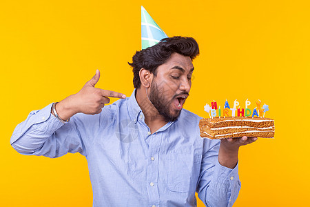 有趣的积极的家伙手里拿着一个自制的蛋糕 上面写着生日快乐 背景是黄色的 假期和周年纪念日的概念 派对 惊喜图片