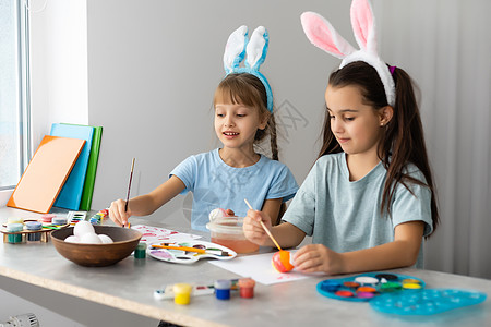 两个可爱的小女孩 在复活节鸡蛋上画画 假期图片