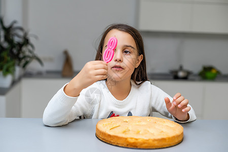 女孩在生日与蛋糕和蜡烛 孩子 学校 快乐的 帽 庆典图片