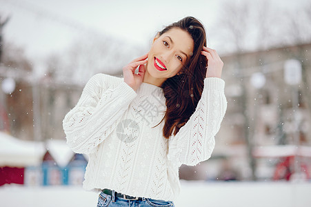 穿着白色毛衣的年轻女孩 站在冬季公园 雪图片