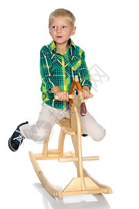 一个小男孩骑着木马 幼儿园 工作室 童年 美丽的 小马图片