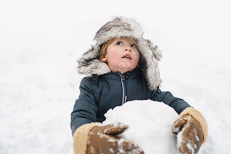 玩雪球的小孩儿在冬日天气时摆姿势图片