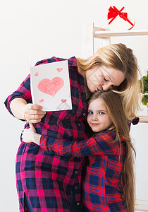 母亲节 假期和家庭假期-母亲拿着她可爱女儿的贺卡 母性 心图片