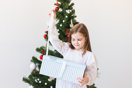 女孩在圣诞树附近打开礼物盒 假日 圣诞节时间和提出概念 笑声 微笑 季节图片