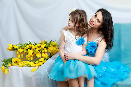 妈妈和女儿在沙发上 带着一束花 自然 快乐的图片
