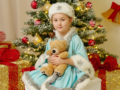 穿着雪雪少女服装的小女孩 还有一只泰迪熊 幸福 圣诞节图片
