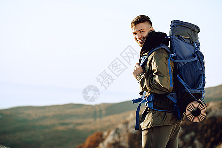 年轻的天主教男子旅行者 在山上徒步旅行 背着大背包在山上远足 活动 攀登图片