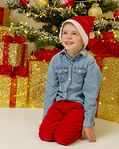 圣诞树附近有个小男孩 带着礼物 男生 快乐 十二月图片