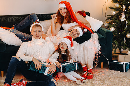 一个幸福的家庭坐在庆祝节日的圣诞树附近的沙发上的近似肖像 假期 爸爸图片