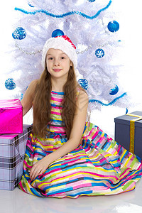 一个带着圣诞老人帽子的礼物的小姑娘 圣诞节 童年图片