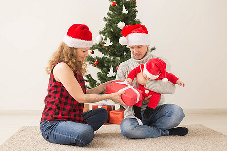 快乐的一对夫妇与婴儿 一起庆祝圣诞节在家里 男人图片