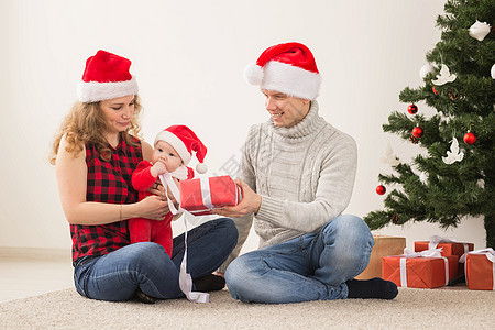 快乐的一对夫妇与婴儿 一起庆祝圣诞节在家里 房间 家庭图片