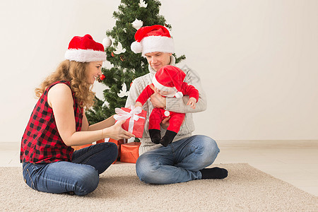快乐的一对夫妇与婴儿 一起庆祝圣诞节在家里 家庭 房间图片